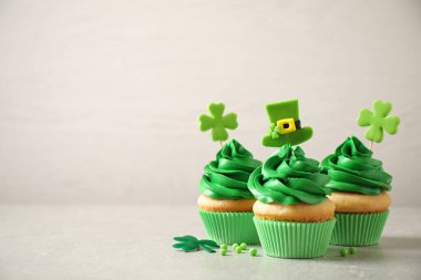 Delicious decorated cupcakes on light table, space for text. St. Patrick's Day celebration