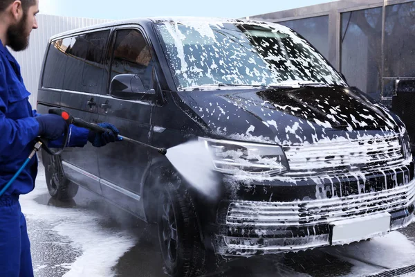 Trabajador de limpieza de automóviles con chorro de agua de alta presión en el coche w — Foto de Stock