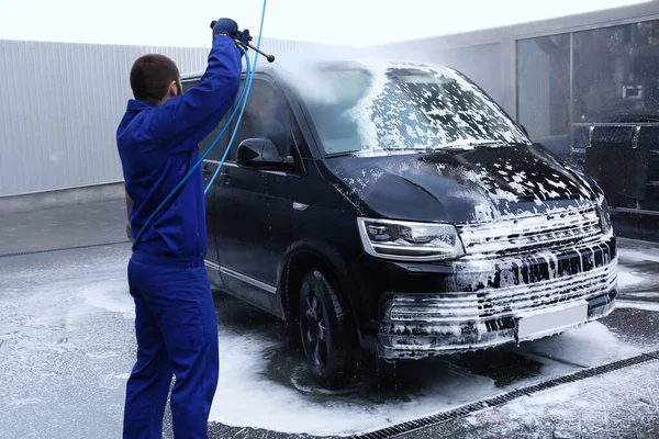 Worker cleaning automobile with high pressure water jet at car w — 스톡 사진