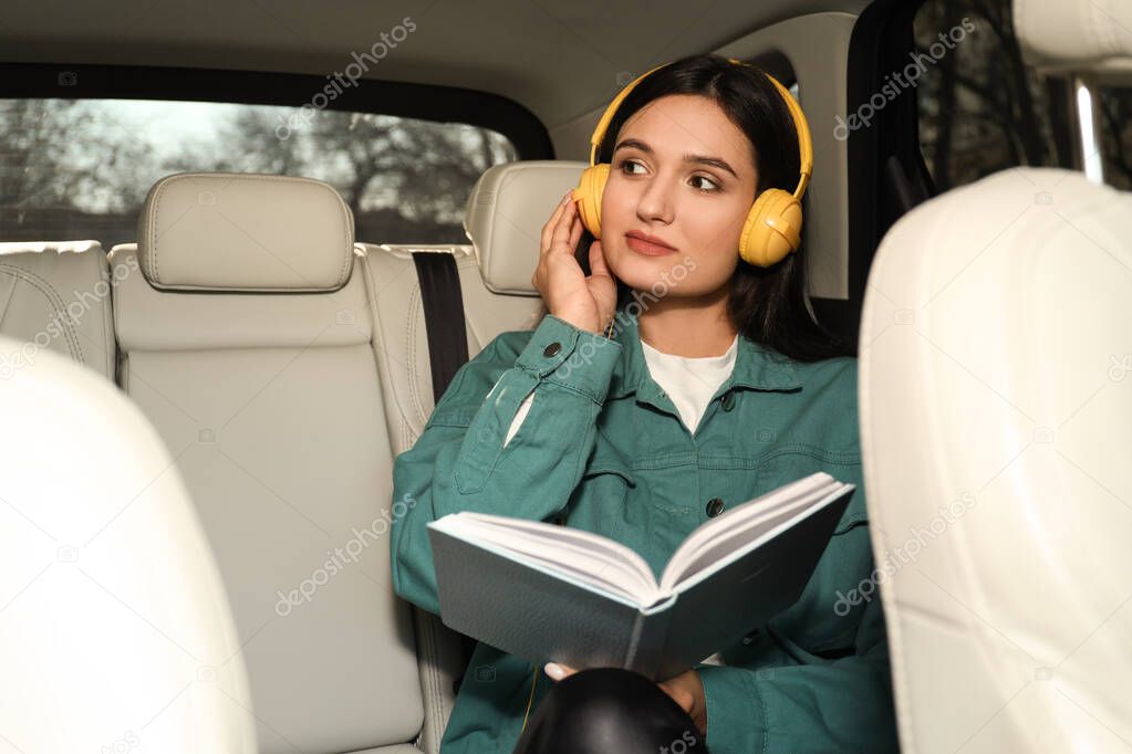 Young woman listening to audiobook in car