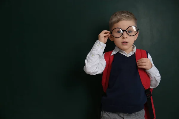 Lindo niño pequeño con gafas cerca de pizarra, espacio para tex —  Fotos de Stock