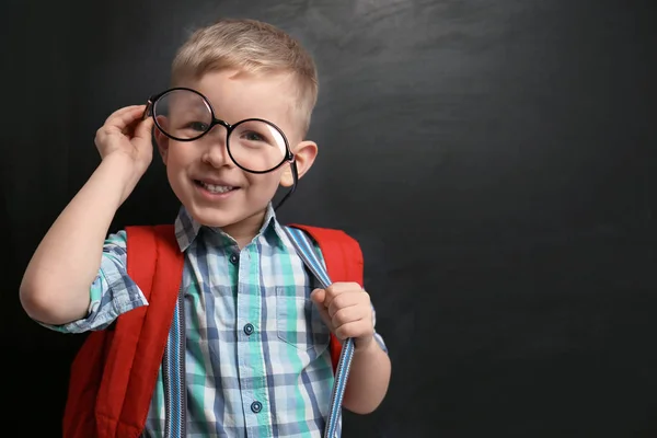 Gracioso niño pequeño con gafas cerca de pizarra, espacio para te —  Fotos de Stock