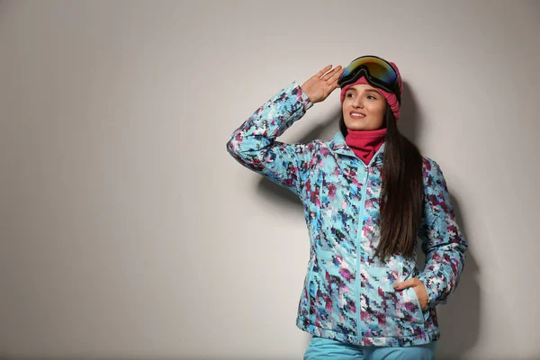 Женщина в стильной зимней спортивной одежде на светло-сером бэкгро — стоковое фото