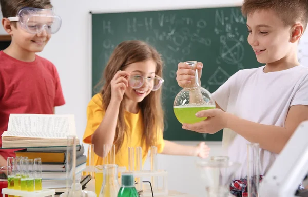 Chytří žáci, kteří dělají experiment ve třídě chemie — Stock fotografie