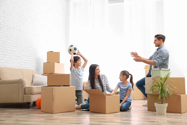 Счастливая семья распаковывает коробки в своем новом доме — стоковое фото