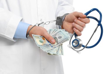 Doktor, rüşvetle kelepçelenmiş ve steteskop takmış.