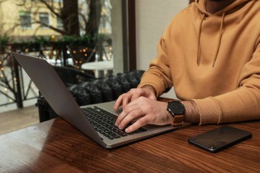 Kafedeki masada dizüstü bilgisayarla çalışan erkek blogcu, yakın plan