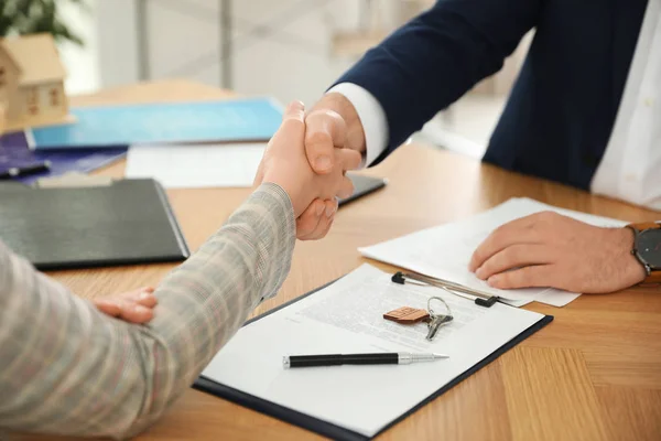 Agente de bienes raíces estrechando la mano con el cliente en la oficina, primer plano — Foto de Stock