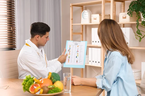 Nutritionniste consultant patient à table en clinique — Photo