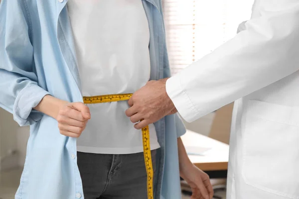 Voedingsdeskundige meet taille van jonge patiënt in kliniek, close-up — Stockfoto