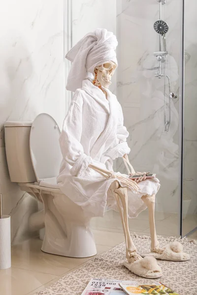 Esqueleto Roupão Banho Com Telefone Móvel Sentado Vaso Sanitário — Fotografia de Stock