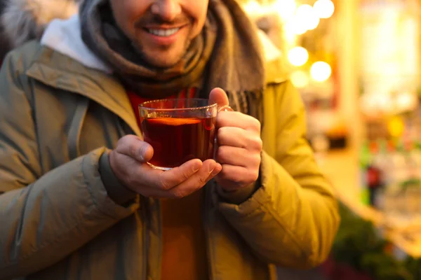 Szczęśliwy człowiek z grzanym winem na targach zimowych, zbliżenie — Zdjęcie stockowe