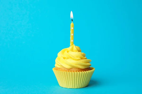 Delicioso cupcake de cumpleaños con crema amarilla y vela encendida —  Fotos de Stock