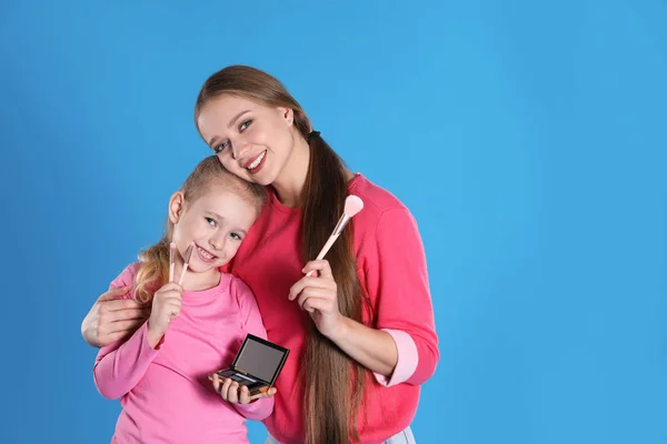 Счастливые мать и дочь с косметикой на голубом фоне. Озил — стоковое фото