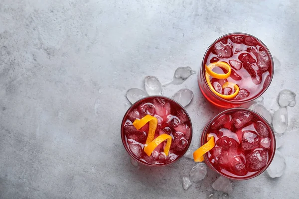 Coquetéis Negroni frescos com raspas de laranja na mesa cinza, flat lay — Fotografia de Stock