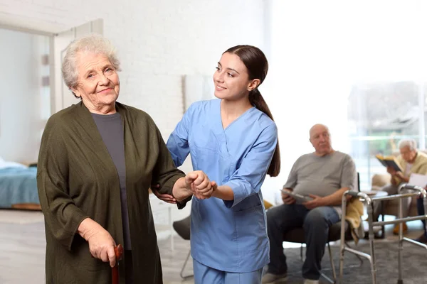 Νοσοκόμα που φροντίζει ηλικιωμένη γυναίκα σε γηροκομείο — Φωτογραφία Αρχείου