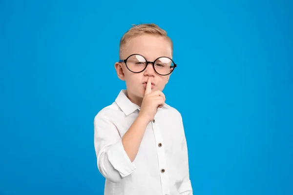 Retrato de menino bonito em óculos no fundo azul claro — Fotografia de Stock