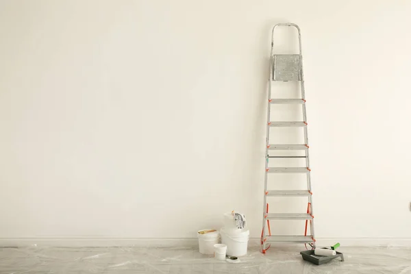 Escalera y diferentes herramientas cerca de la pared en la habitación, espacio para el texto — Foto de Stock