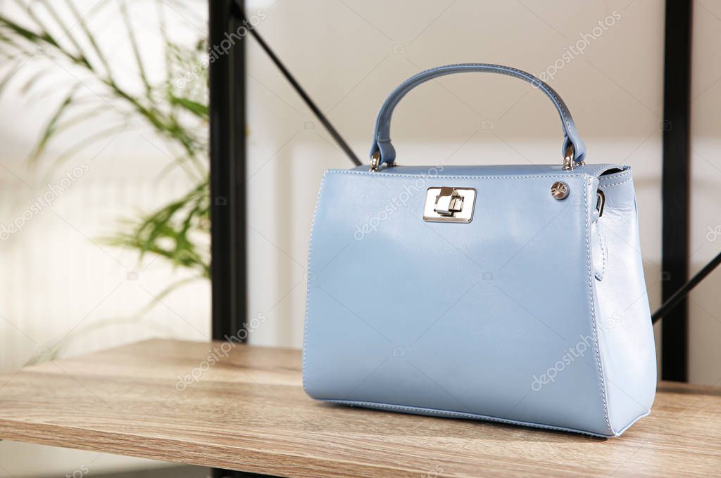 Light blue woman's bag on wooden shelf