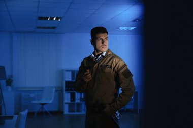 Koyu ofili telsizi olan profesyonel güvenlik görevlisi.