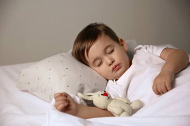 Evde oyuncakla uyuyan şirin bir bebek. Yatma zamanı.