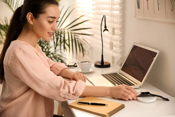 Vrouw zet smartwatch op draadloze lader aan witte tafel. M — Stockfoto