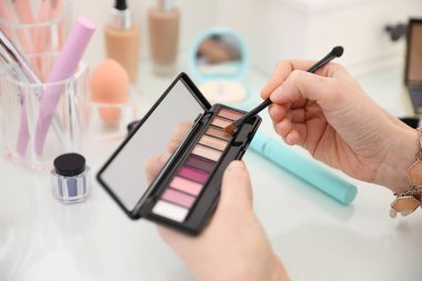 Makyaj masasına makyaj yapan kadın, yakın plan.