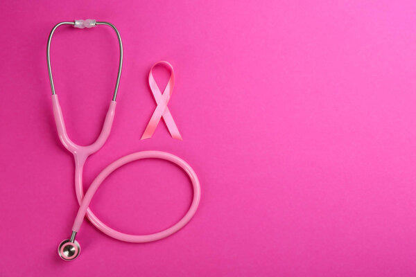 Pink ribbon as breast cancer awareness symbol and stethoscope on color background, flat lay. Space for text