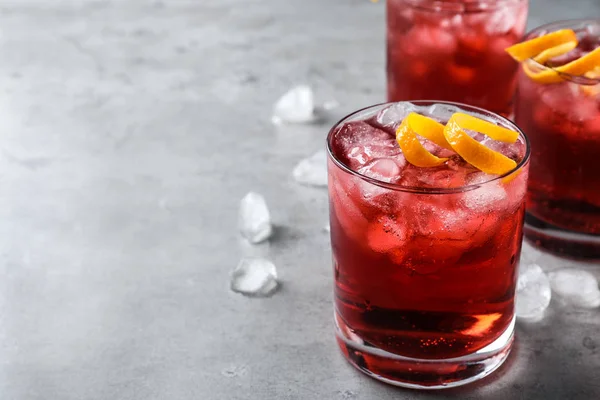 Cocktail Negroni fresco com raspas de laranja na mesa cinza. Espaço para — Fotografia de Stock