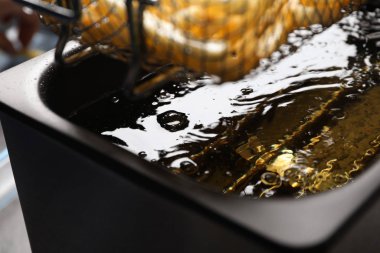 Lezzetli patates kızartması pişiriyorum, sıcak yağda, yakından.