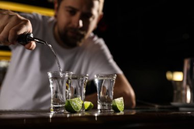 Barmen bardaki bardağa Meksika tekilasını dolduruyor, yakın plan. Metin için boşluk