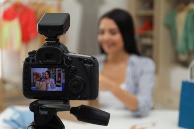 Moda blogcusu içerideki masada yeni video kaydediyor, kameraya odaklan