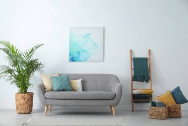 Oturma odasındaki kanepede farklı yumuşak yastıklar.