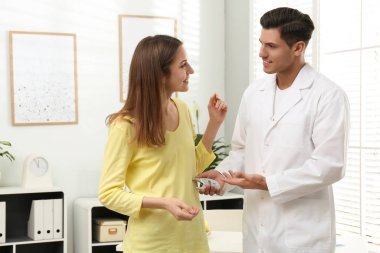 Beslenme uzmanı, hastanın vücut yağını dijital kalibre ile ölçüyor.