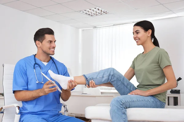 Mannelijke orthopeed die de binnenzool op de voet van de patiënt in de kliniek aanbrengt — Stockfoto