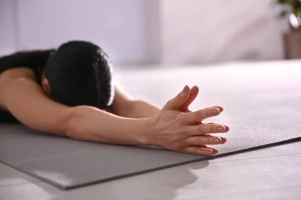 Mujer joven practicando asana de niño extendido en estudio de yoga, cl — Foto de Stock