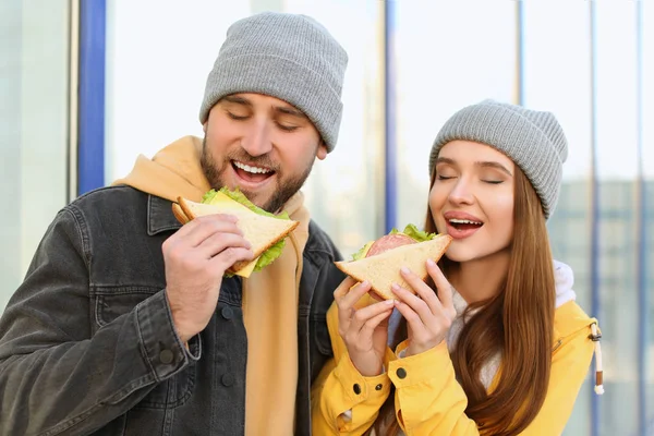 Szczęśliwa młoda para z kanapkami na ulicy miasta — Zdjęcie stockowe