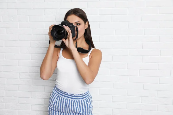 Fotógrafo profissional trabalhando perto de parede de tijolo branco em studi — Fotografia de Stock