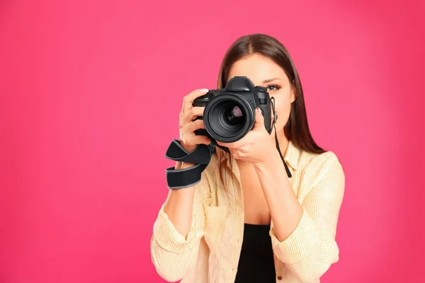 Profesionální fotograf pracující na růžovém pozadí ve studiu. — Stock fotografie