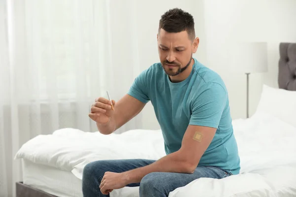 一个有尼古丁贴片和香烟在卧室里的情绪化男人 — 图库照片