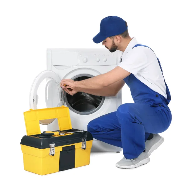 Plumber repairing washing machine on white background — Stock Photo, Image