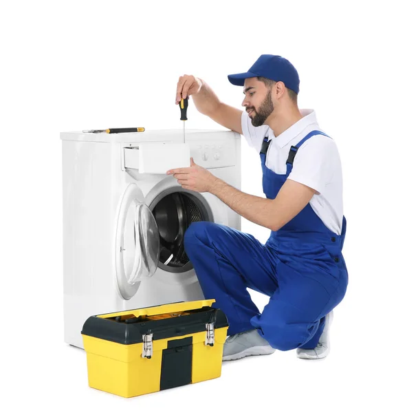 Plumber repairing washing machine on white background — Stock Photo, Image