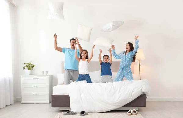 Feliz família brincando com travesseiros no quarto — Fotografia de Stock