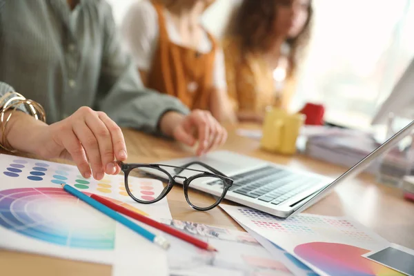 Kvinnlig designer arbetar med bärbar dator vid bordet, närbild — Stockfoto