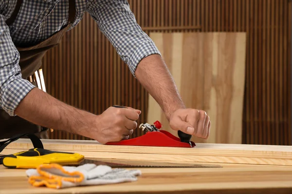 Carpintero trabajando con madera en la mesa en interiores, primer plano — Foto de Stock