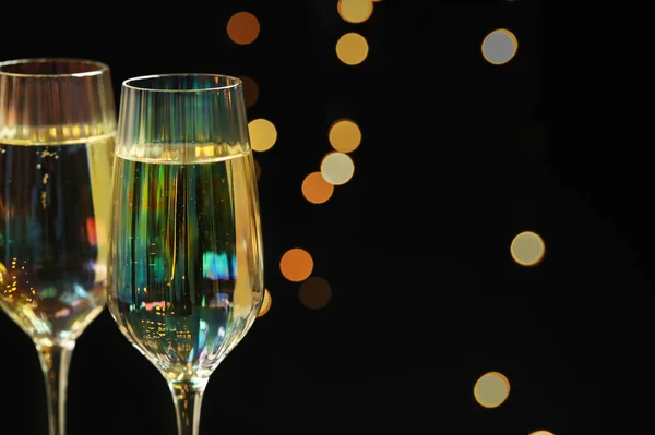 Sklenice šampaňského proti rozmazaným světlům, detailní záběr. Mezera pro — Stock fotografie