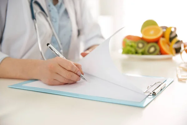 Nutricionista trabajando en el escritorio en la oficina, primer plano — Foto de Stock