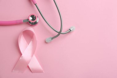 Renkli arka planda pembe kurdele ve steteskop, S ile düz yatıyordu.