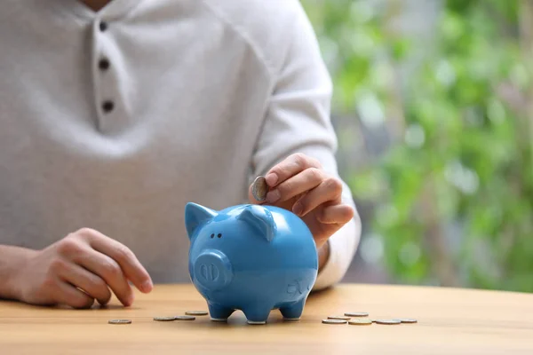 Man Putting Money Piggy Bank Table Closeup — Stock Photo, Image