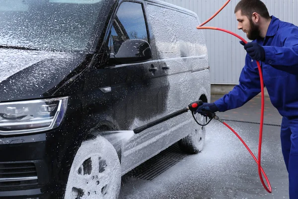 Trabalhador cobrindo automóvel com espuma na lavagem de carro — Fotografia de Stock